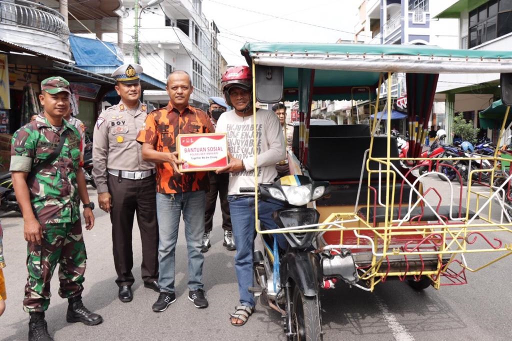 Jajaran Polres Kepulauan Meranti, perwakilan Pemuda Pancasila dan TNI turun ke jalan berbagi paket sembako, Jumat (9/9/2022).